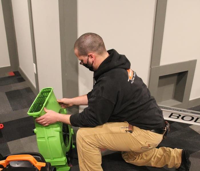 SERVPRO worker setting up a air mover