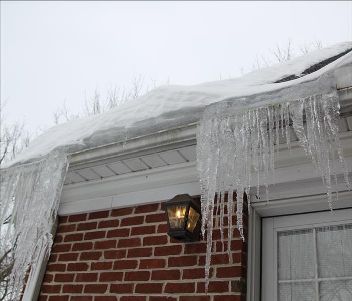Long icicles hang off the edge of a white gutter.